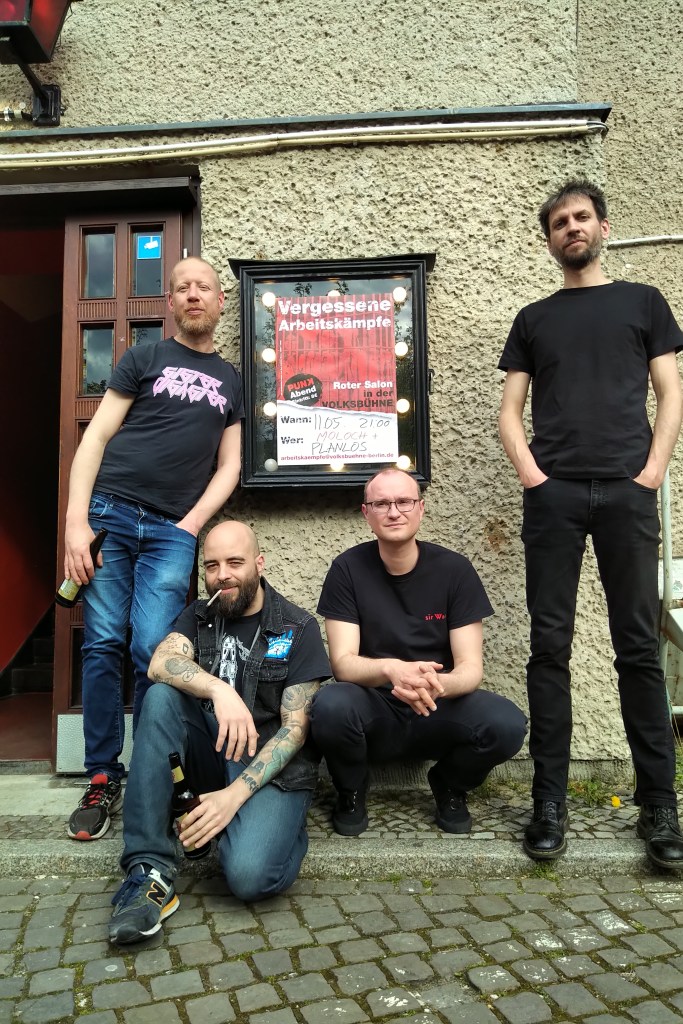 Moloch posiert vorm Plakat zum Konzert in der Volksbühne